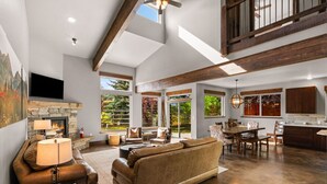A spacious living area with a fireplace, comfortable seating, and a kitchen area with wooden cabinets.