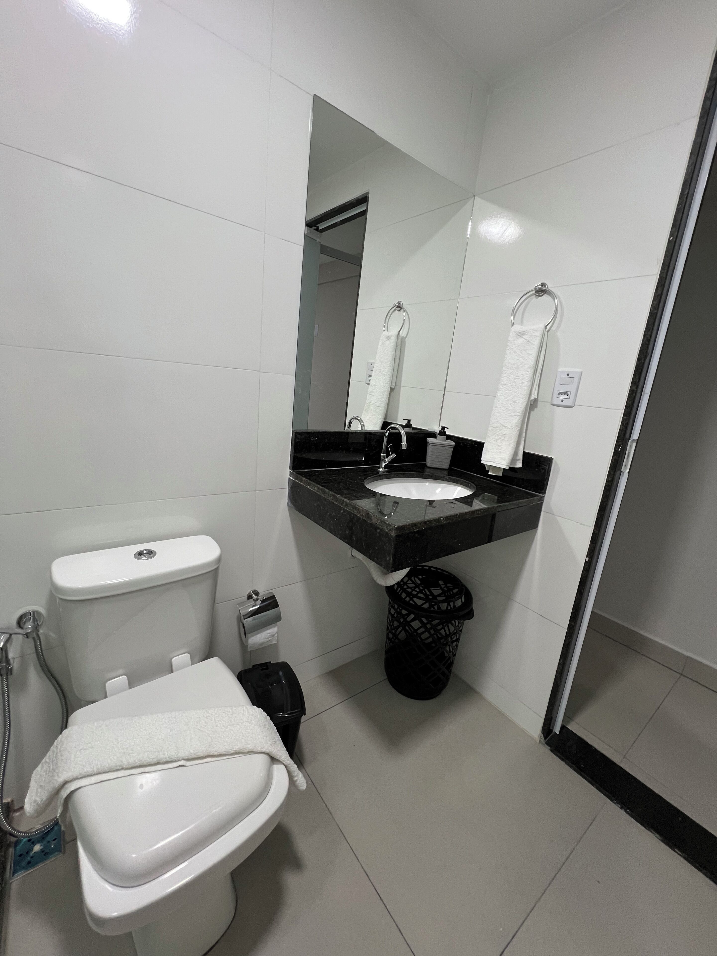 Un baño moderno con inodoro, lavabo, espejo y bidé.