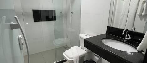 A modern bathroom with a glass-enclosed shower, a white toilet, a black sink, and a mirror above the sink.