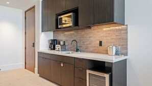 A modern kitchen with dark cabinetry, a microwave, a toaster, and a dishwasher. - Argent At Deer Valley Resort - Hotel Room #105b Hotel Room (Park City)