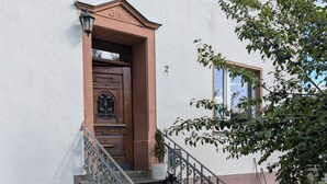 A building with a stone staircase, a door with a number plate, and a potted plant. - Vacation apartment in Bungert - directly on the Eifelsteig trail (Üxheim)