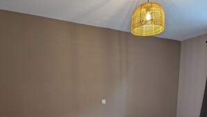 A bedroom with a bed, bedside tables, a lamp, and a hanging light fixture. - Vacation apartment in Bungert - directly on the Eifelsteig trail (Üxheim)