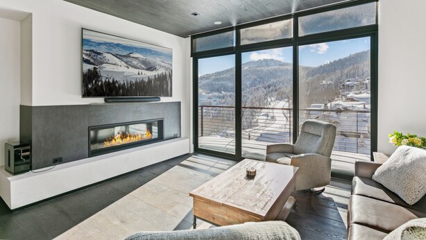 A modern living room with a fireplace, large windows, and a view of a snowy landscape. - Argent at Deer Valley Resort - Two Bedroom Deluxe #401 2 Condo (Park City)