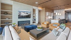 A modern living room with a fireplace, sofas, and a television.