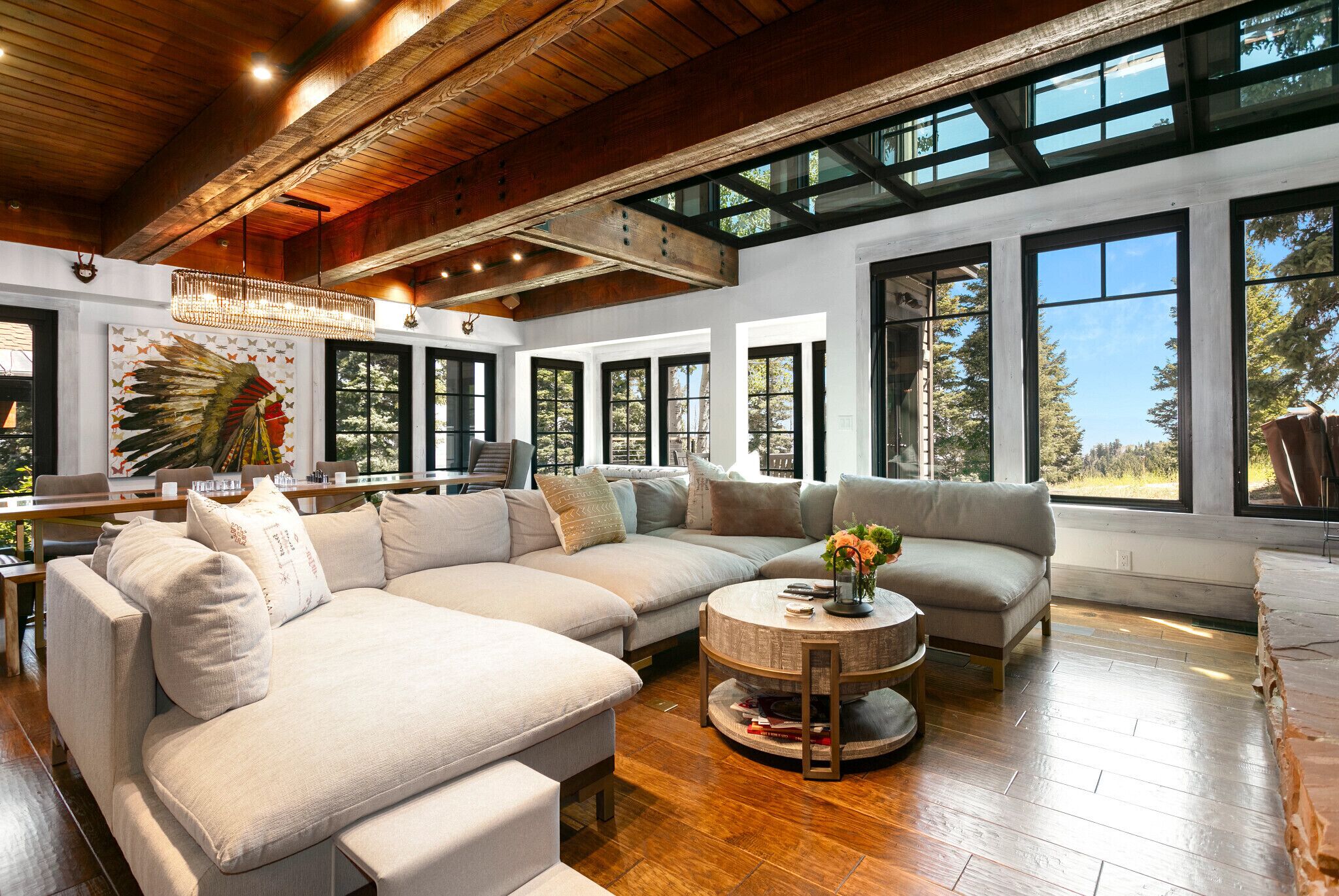 A spacious living room with a large sectional sofa, a round coffee table, and a wooden ceiling.