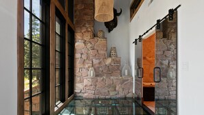 A hallway with stone walls, a glass floor, and a mounted animal head. - Stag Lodge At Deer Valley Resort - 4 Bed W/ Spa #7 4 Bedroom Condo (Park City)