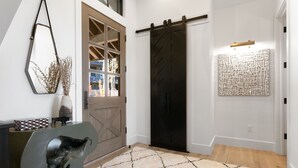 A modern interior with a sliding barn door, a geometric wall art piece, and a textured rug. - Tower Villas - Five Bedroom Villa w/ Hot Tub #7700 by Deer Valley Resort (Park City)