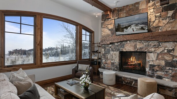 A cozy living room with a stone fireplace, large windows, and a comfortable seating area. - Grand Lodge - Three Bedroom Condo #201 - Ski-in/ski-out by Deer Valley Resort (Park City)