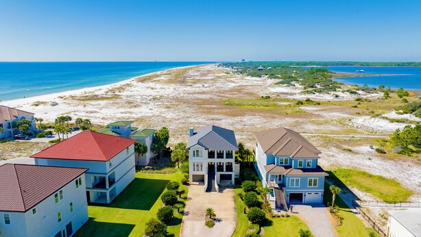 A beachfront property with multiple houses, a well-maintained lawn, and a clear view of the ocean. - Gulf and Lagoon Views | Elevator | Community Pool (Gulf Shores)