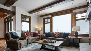 A cozy living room with leather sofas, a wooden coffee table, and large windows with blinds. - Grand Lodge - Three Bedroom Condo #401 - Ski-in/ski-out by Deer Valley Resort (Park City)
