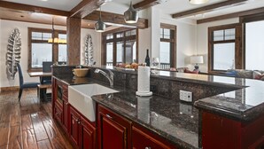 A spacious kitchen with granite countertops, wooden cabinets, and a large island. - Grand Lodge - Three Bedroom Condo #401 - Ski-in/ski-out by Deer Valley Resort (Park City)