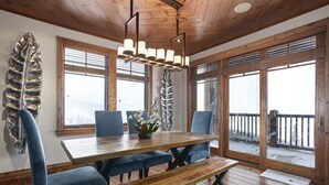A wooden dining table with blue upholstered chairs, a bench, and a decorative leaf sculpture on the wall. - Grand Lodge - Three Bedroom Condo #401 - Ski-in/ski-out by Deer Valley Resort (Park City)