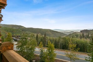 A scenic view of a road with a forested valley and distant hills. - Grand Lodge - 3 Bedroom Condo Deluxe #407 - Ski-in/out by Deer Valley Resort (Park City)
