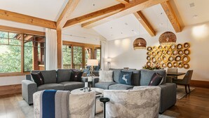 Een moderne woonkamer met een hoekbank, een salontafel en een decoratieve wand met ronde patronen.