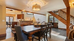 A spacious kitchen with wooden cabinetry, a central island, and a dining area with a wooden table and chairs. - Ridgepoint - Three Bedroom Condo with Spa #128 by Deer Valley Resort (Park City)