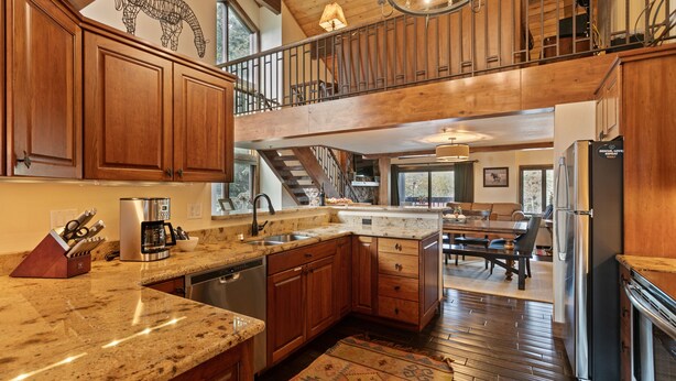 A spacious kitchen with granite countertops, wooden cabinets, and a stainless steel refrigerator. - Ridgepoint - Three Bedroom Condo with Spa #128 by Deer Valley Resort (Park City)