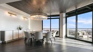 A modern dining area with a round table, grey chairs, and a chandelier. - 201 - Four Bedroom Argent 4 Condo by Deer Valley Resort (Park City)