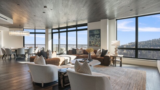 A spacious living room with a high ceiling, large windows, and a view of a forested area. - 201 - Four Bedroom Argent 4 Condo by Deer Valley Resort (Park City)