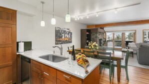 A modern kitchen with a marble countertop, wooden cabinets, and pendant lighting. - 1490 - Three Bedroom Condo with Spa Aspenwood by Deer Valley Resort (Park City)