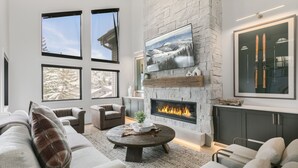 A modern living room with a fireplace, large windows, and ski-themed decor. - 1072 - Three Bedroom Condo with Spa Boulder Creek by Deer Valley Resort (Park City)