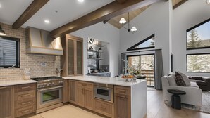 A modern kitchen with wooden cabinets, a built-in oven, and a large island. - 1072 - Three Bedroom Condo with Spa Boulder Creek by Deer Valley Resort (Park City)