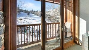 A wooden door with glass panels leading to a balcony with a view of a snowy landscape. - 504 - Five Bedroom Condo Penthouse Grand Lodge by Deer Valley Resort (Park City)