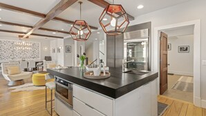 A modern kitchen with a central island, stainless steel appliances, and a wooden ceiling. - 6977 Silver Lake Drive - 5 Bedroom Private Home with Hot Tub by Deer Valley Resort (Park City)