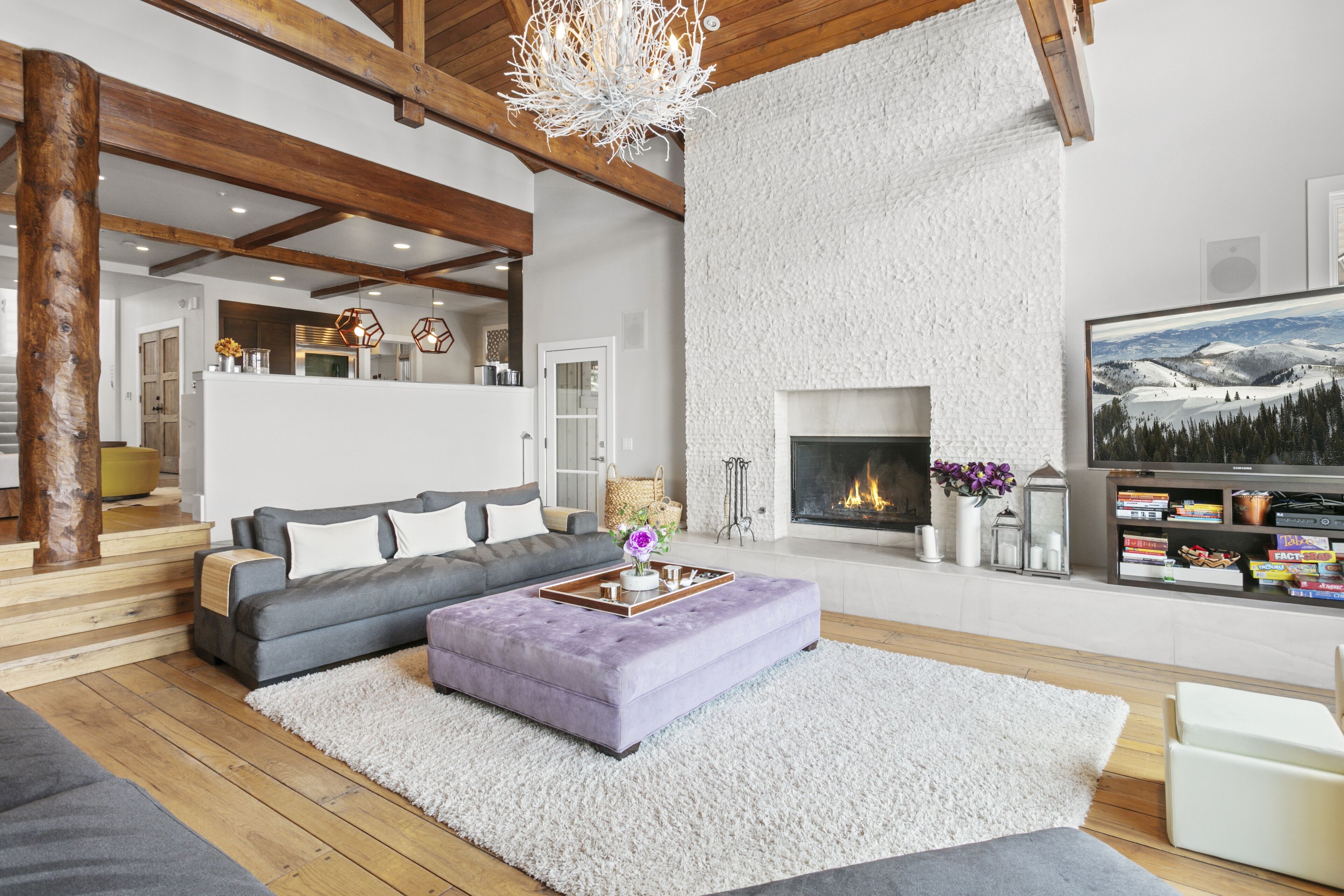 A modern living room with a fireplace, a sofa, a coffee table, and a bookshelf.