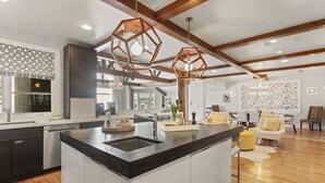 A modern kitchen with a central island, wooden beams, and pendant lighting. - 6977 Silver Lake Drive - 5 Bedroom Private Home with Hot Tub by Deer Valley Resort (Park City)