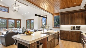 Una cocina amplia con armarios de madera, una isla grande y un comedor con sofá y mesa de centro.