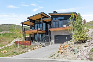 A modern two-story house with a covered porch, a garage, and a landscaped driveway.
