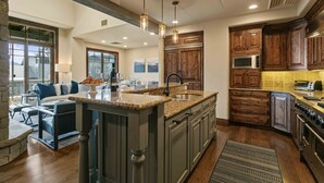 Una cocina amplia con encimeras de granito, armarios de madera y una isla central.