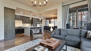 A spacious living area with a modern sofa, a coffee table, and a dining area with chairs.