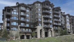 A multi-story building with balconies, large windows, and a stone facade. - 302 - Four Bedroom Condo Silver Strike by Deer Valley Resort (Park City)