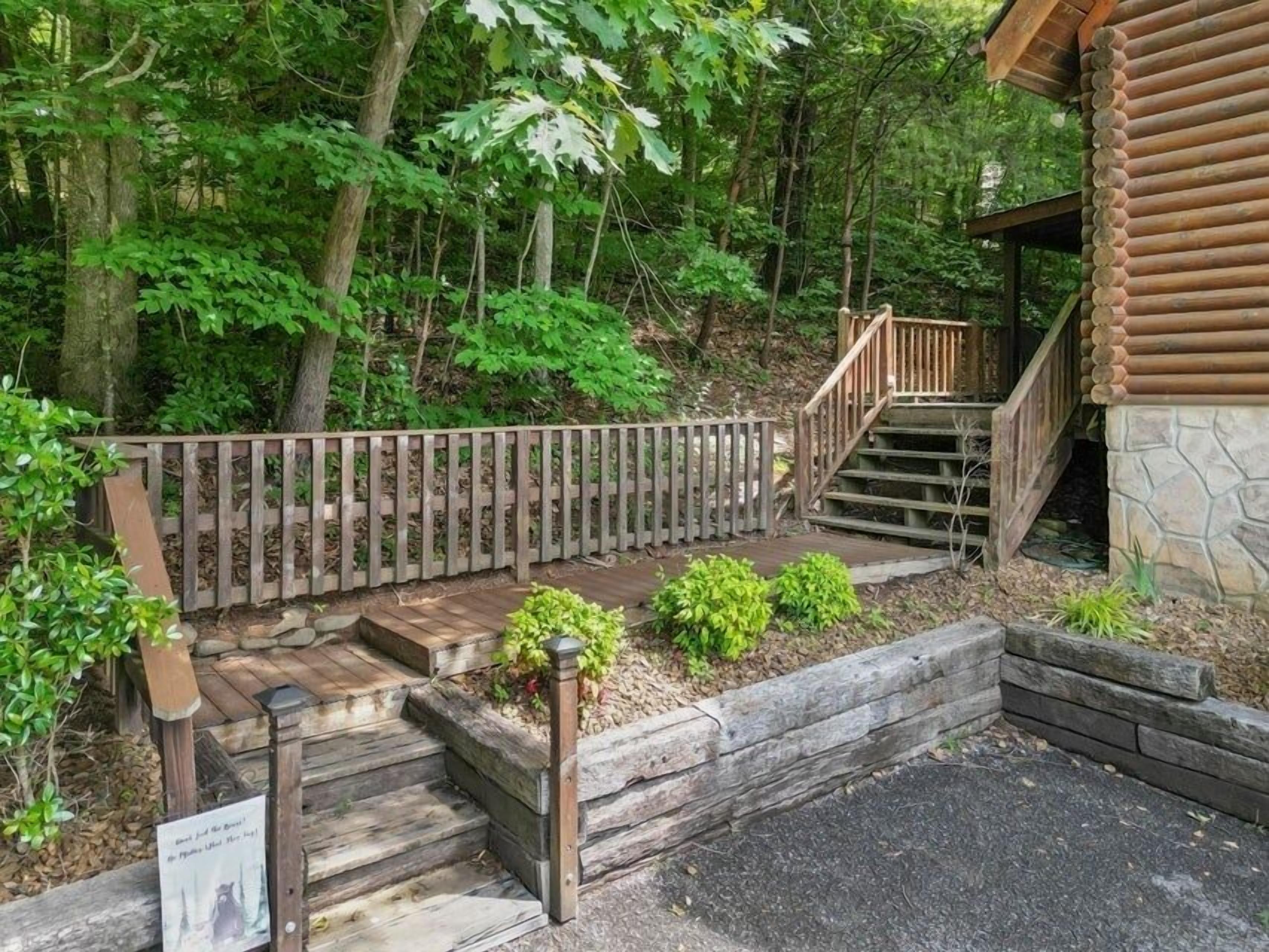 A wooden staircase leading to a cabin surrounded by dense forest.
