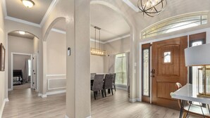A spacious interior with a dining area, wooden door, and a chandelier. - New Heights Home | 8 Bd | 2 mi to Still House Lake Perfect for families & groups (Harker Heights)