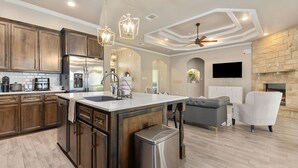 A spacious kitchen with wooden cabinets, a stainless steel refrigerator, and a central island. - New Heights Home | 8 Bd | 2 mi to Still House Lake Perfect for families & groups (Harker Heights)