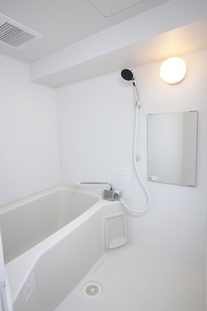 Bañera con ducha, secador de pelo, pantuflas, toallas