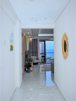 A modern interior with a hallway leading to a balcony with a view.