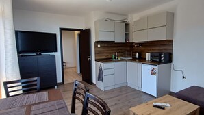 Een knus woongedeelte met een kitchenette, een eethoek en een zithoek.