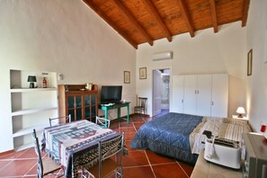 A bedroom with a bed, a desk, a chair, a television, and a wardrobe. - The Scola of Pirazzolu Retreat (Olbia)