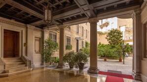 Un hall d’entrée spacieux, doté d’un sol en marbre, d’un tapis rouge et de colonnes de style classique.