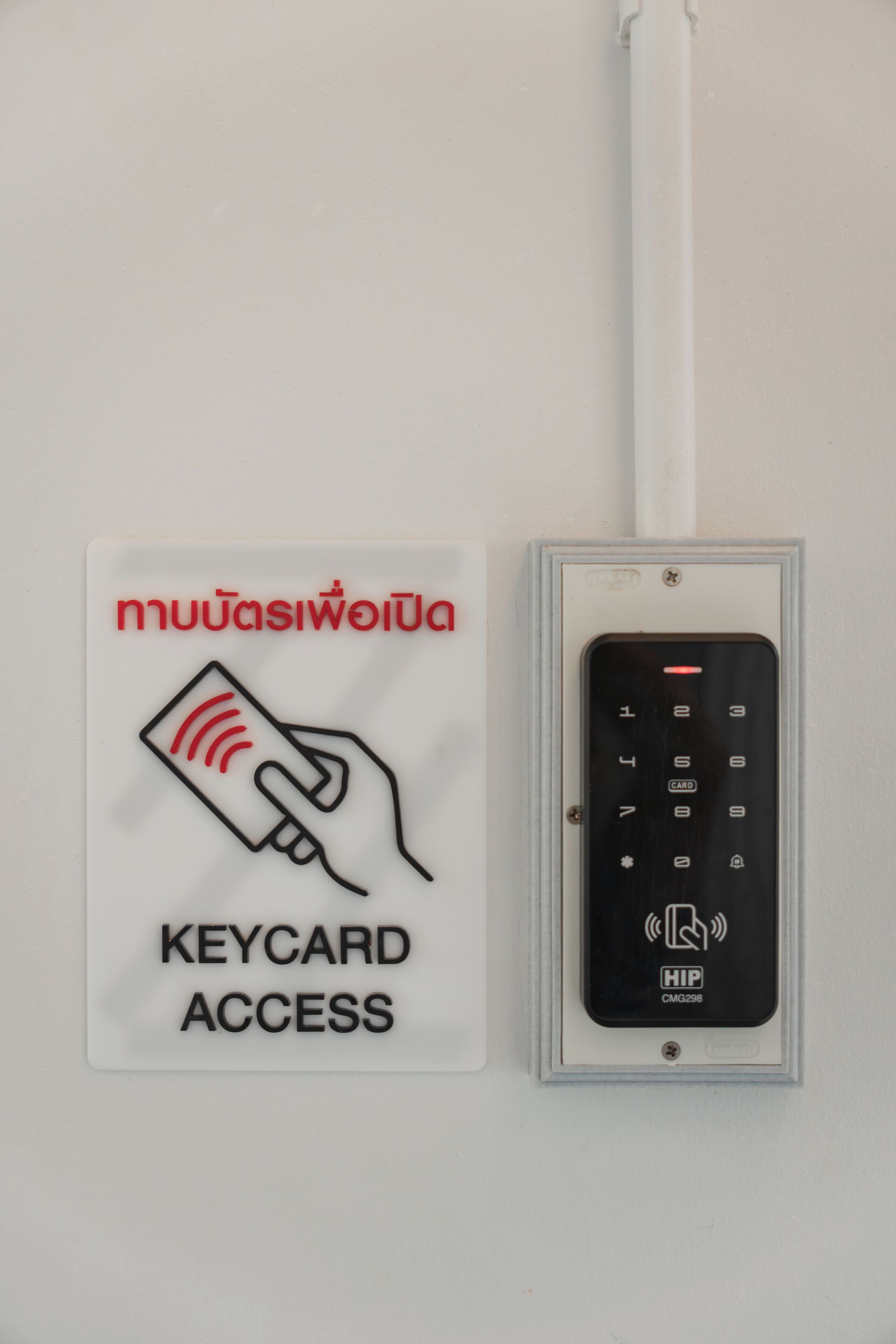 A sign indicating keycard access and a keypad with a wireless symbol.