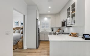 Een moderne keuken met witte kasten, een centraal eiland en een zithoek.