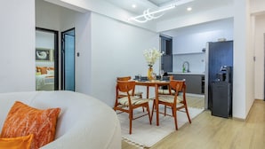 Un appartement moderne comprenant un coin repas, une cuisine et un salon avec un canapé et des coussins.