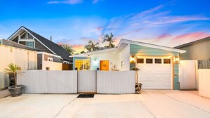 A residential property with a garage, a covered porch, and a fenced backyard. - 25% Off 30+ Stay! Steps To Sand, Great Location (Oxnard)