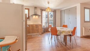 Un espace repas comprenant une table, des chaises et un luminaire suspendu.