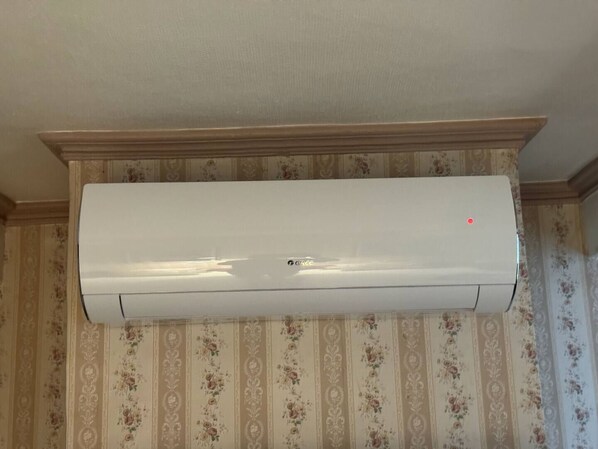 Un equipo de aire acondicionado blanco montado en una pared con estampado floral.