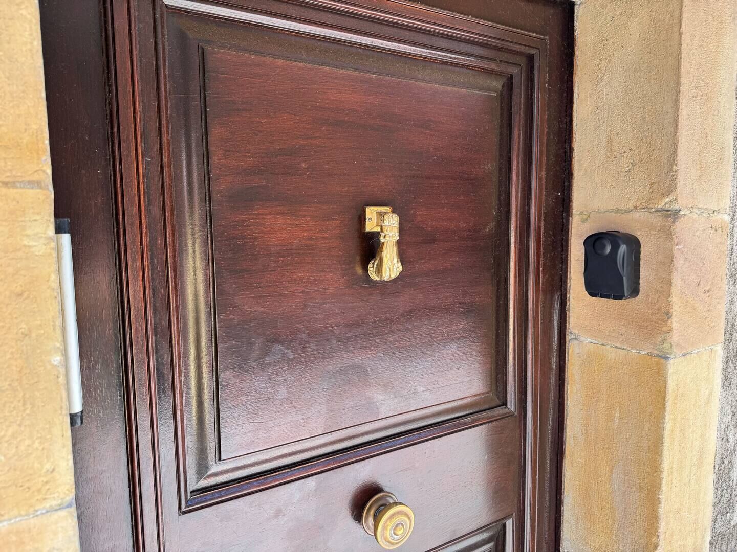 A wooden door with a brass handle and a keyhole.