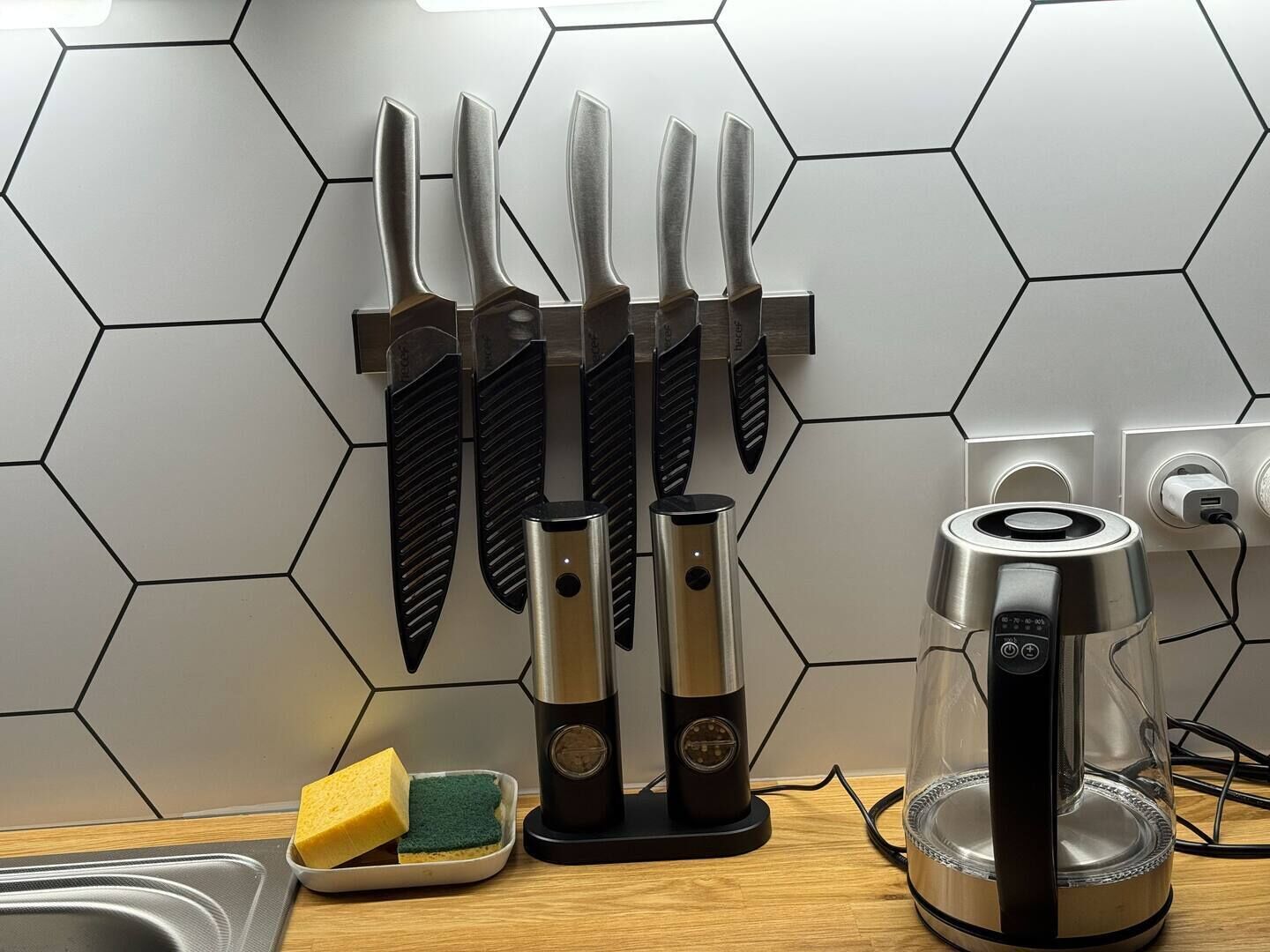 Une cuisine équipée d’un bloc à couteaux, d’une machine à café et de produits de nettoyage.